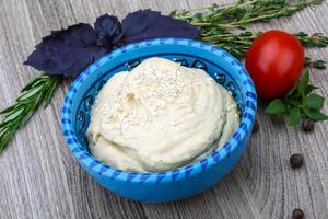 Hummus in einer Schüssel auf Holzhintergrund foto