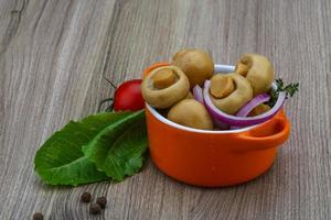 marinierte Champignons in einer Schüssel auf Holzhintergrund foto