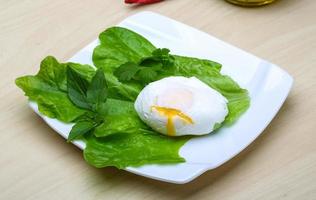 egg benedict auf dem teller und dem hölzernen hintergrund foto