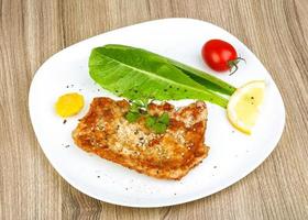 Schweineschnitzel auf dem Teller und Holzhintergrund foto