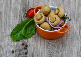 marinierte Champignons in einer Schüssel auf Holzhintergrund foto