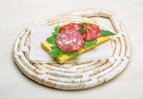 Salami-Sandwich auf Holzbrett und Holzhintergrund foto