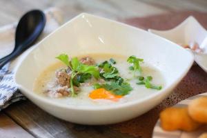 Brei nach chinesischer Art oder Brei und gebratener Teigstab oder gebratener Teigstab oder Donut oder gebratenes Brot auf einem Holztisch. thailändisches Straßenessen heißt Haferbrei und Patongo. foto