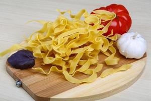 Rohe Tagliatelle auf Holzbrett und Holzhintergrund foto