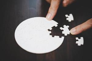 Geschäftsfrau-Personenhand mit Puzzleteilidee für Strategie und Lösung. Closeup Teil von zwei weißen Puzzles verbinden sich. konzept des gemeinsamen zusammenarbeitserfolgs teamwork-problem unternehmensteam. foto