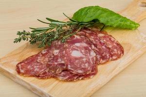 Salami auf Holzbrett und Holzhintergrund foto