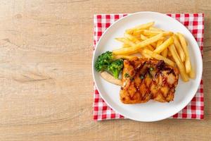 gegrilltes Hähnchensteak mit Kartoffelchips oder Pommes frites foto