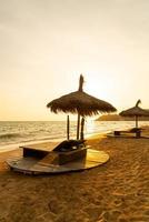 Strandkorb und Sonnenschirm mit Meeresstrand Hintergrund foto