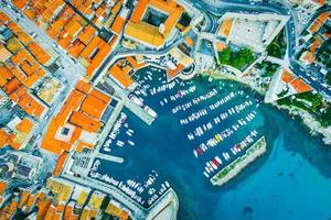 luftaufnahme hinunter zum hafen von dubrovnik mit yachten und booten. besichtigung der kroatischen küste wahrzeichen kreuzfahrt und reise in kroatien. orange Dächer und Architektur foto