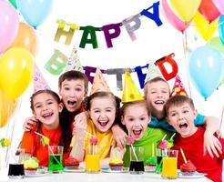 Gruppe von lachenden Kindern, die Spaß an der Geburtstagsfeier haben. foto