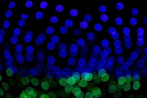 blaue grüne Defokussierung abstrakte Bokeh-Lichteffekte auf der nachtschwarzen Hintergrundtextur foto