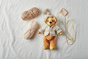 handgefertigter Teddybär und gestrickte kleine Pullover foto