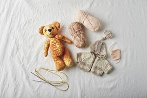 handgefertigter Teddybär und gestrickte kleine Pullover foto