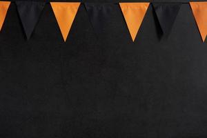 Halloween-Girlande aus schwarzen und orangefarbenen Flaggen auf dunklem Hintergrund mit Platz für Text foto