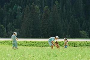 vier kinder spielen auf der alpenwiese in untertauern, österreich. foto