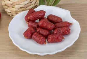 Mini-Salami auf dem Teller und Holzhintergrund foto