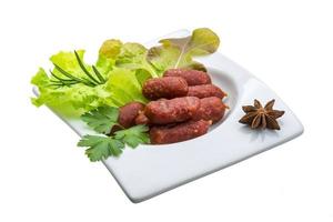 Salamiwürste in einer Schüssel auf weißem Hintergrund foto