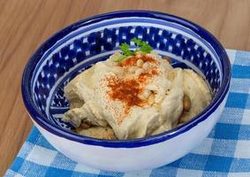 Hummus in einer Schüssel auf Holzhintergrund foto