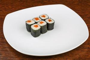 Lachs-Maki auf dem Teller und Holzhintergrund foto