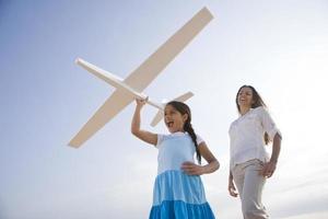 Mutter und Tochter haben Spaß mit Spielzeugflugzeug foto