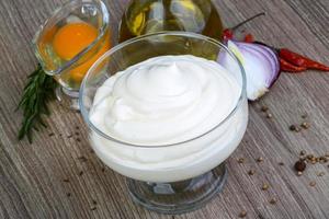 Mayonnaise-Sauce in einer Schüssel auf Holzhintergrund foto