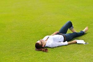 junge Frau, die ein Buch im Park liest foto