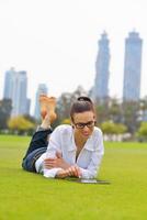 schöne junge Frau mit Tablet im Park foto