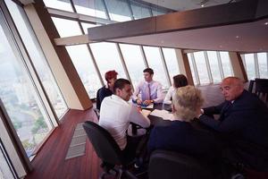 geschäftsleute gruppieren sich beim treffen in einem modernen, hellen büro foto