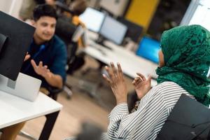 Multiethnische Startup-Business-Team-Araberin, die einen Hijab trägt, trifft sich in einem modernen Großraumbüro, Brainstorming, arbeitet an Laptop und Desktop-Computer. selektiver Fokus foto