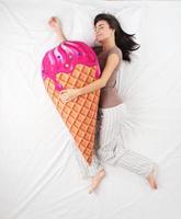 Frau schläft mit Eisspielzeug und träumt von Süßigkeiten