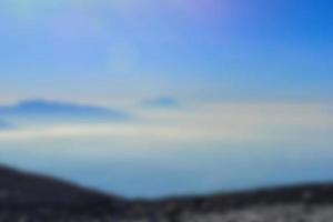 verschwommene Landschaft blauer Himmel mit Wolken, wunderschöner pastellfarbener Landschaftshintergrund der Fantasie, Gradientenhimmel, Sonnenaufgang mit Bergen in der Ferne foto