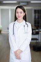 asiatische Ärztin steht selbstbewusst und lächelt. foto