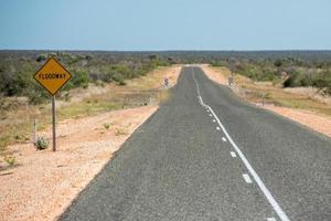 Flutwegschild Westaustralien Wüste endlose Straße foto