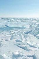 schöne landschaft der transparenten blauen rissigen eisdecke des baikalsees im winter foto