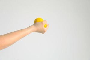 handpressender gelber matschiger ball für muskelübungen oder um sich von stress zu entspannen, konzept der gesundheitsversorgung und medizin. foto