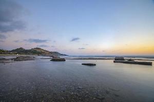 Langzeitbelichtungsfotografie von Wellen und Kieselsteinen am Strand bei Sonnenuntergang foto