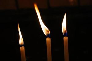 brennende Kerze, die als Hintergrund Licht macht foto