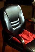 schwarzer Stuhl mit rotem Kissen foto