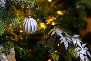 klassischer weihnachtlich geschmückter neujahrsbaum. weihnachtsbaum mit weißen und silbernen dekorationen, ornamenten spielzeug und ball. moderne Innenarchitekturwohnung im klassischen Stil. Heiligabend zu Hause. foto