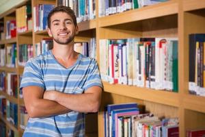Student lächelt in der Kamera in der Bibliothek foto