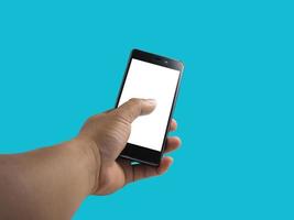 menschliche Hand, die ein Smartphone mit leerem Bildschirm auf blauem Hintergrund isoliert hält. foto