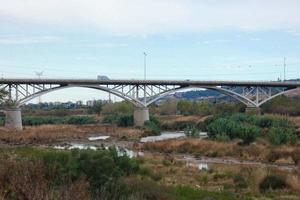 moderne Brücke über einen Fluss, über den große Fahrzeuge und Touristen fahren. foto