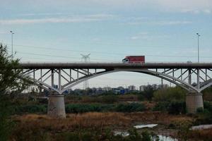 moderne Brücke über einen Fluss, über den große Fahrzeuge und Touristen fahren. foto