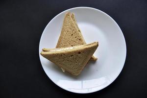 Fleischsandwich mit Fleisch und Soße auf einem weißen Teller. leckeres leichtes Frühstück. foto