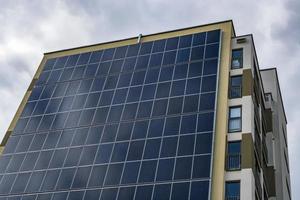 Sonnenkollektoren an der Wand eines mehrstöckigen Gebäudes. erneuerbare Sonnenenergie. foto