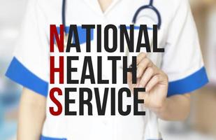 Wörter des nationalen Gesundheitsdienstes und die Hand des Arztes mit Marker foto