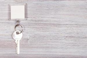 Schlüssel mit Schlüsselanhänger auf Holzoberfläche foto