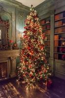 klassisches weihnachtsneujahr dekorierter innenraum neujahrsbaum mit silbernen und roten ornamentdekorationen foto
