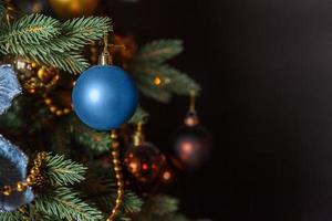 klassischer, weihnachtlich geschmückter neujahrsbaum mit goldenen ornamentdekorationen, spielzeug und ball foto