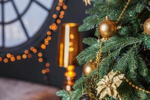klassischer, weihnachtlich geschmückter neujahrsbaum mit goldenen ornamentdekorationen, spielzeug und ball foto
